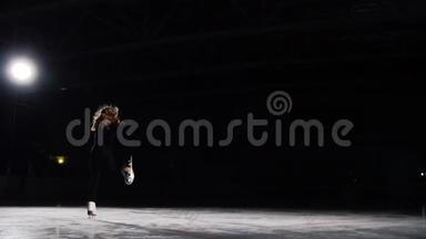 一名职业<strong>花样滑冰</strong>运动员穿着黑色西装，在空中跳跃，以黑色背景表演<strong>滑冰</strong>。慢